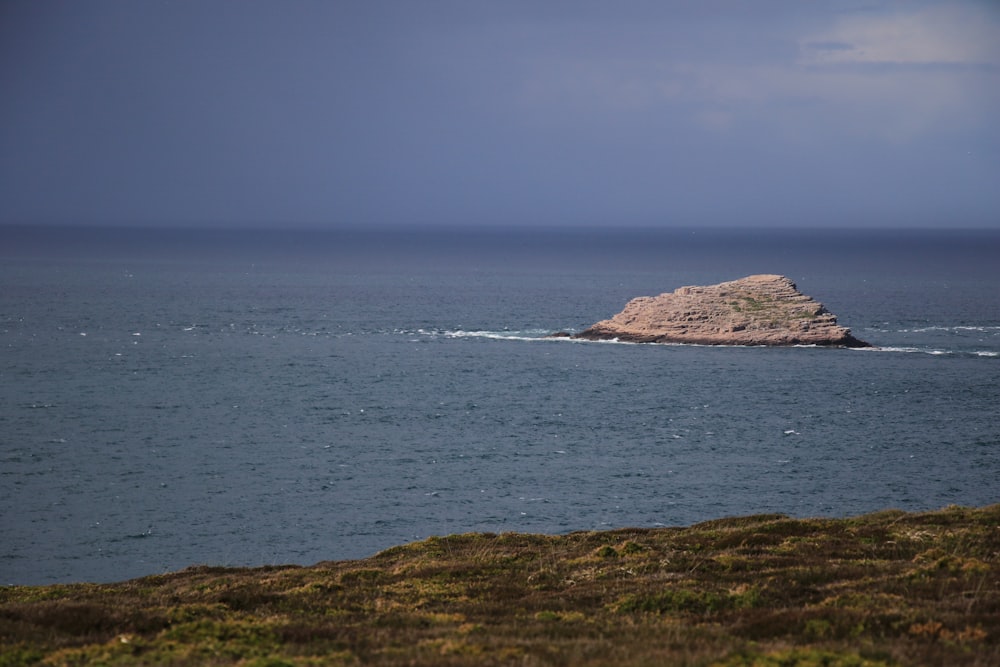 brown rock formation on sea during daytime