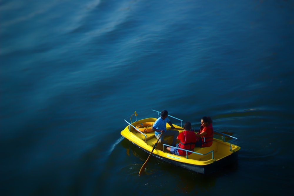man and woman riding yellow kayak on blue sea during daytime