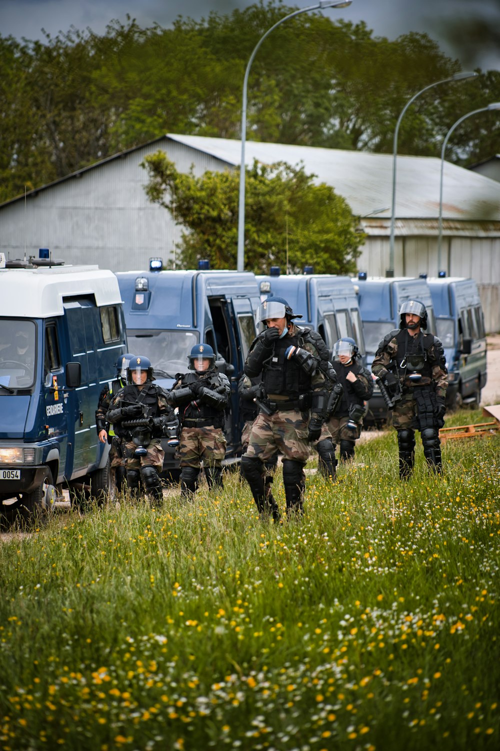 Soldaten in schwarzer und brauner Uniform, die tagsüber auf grünem Gras stehen