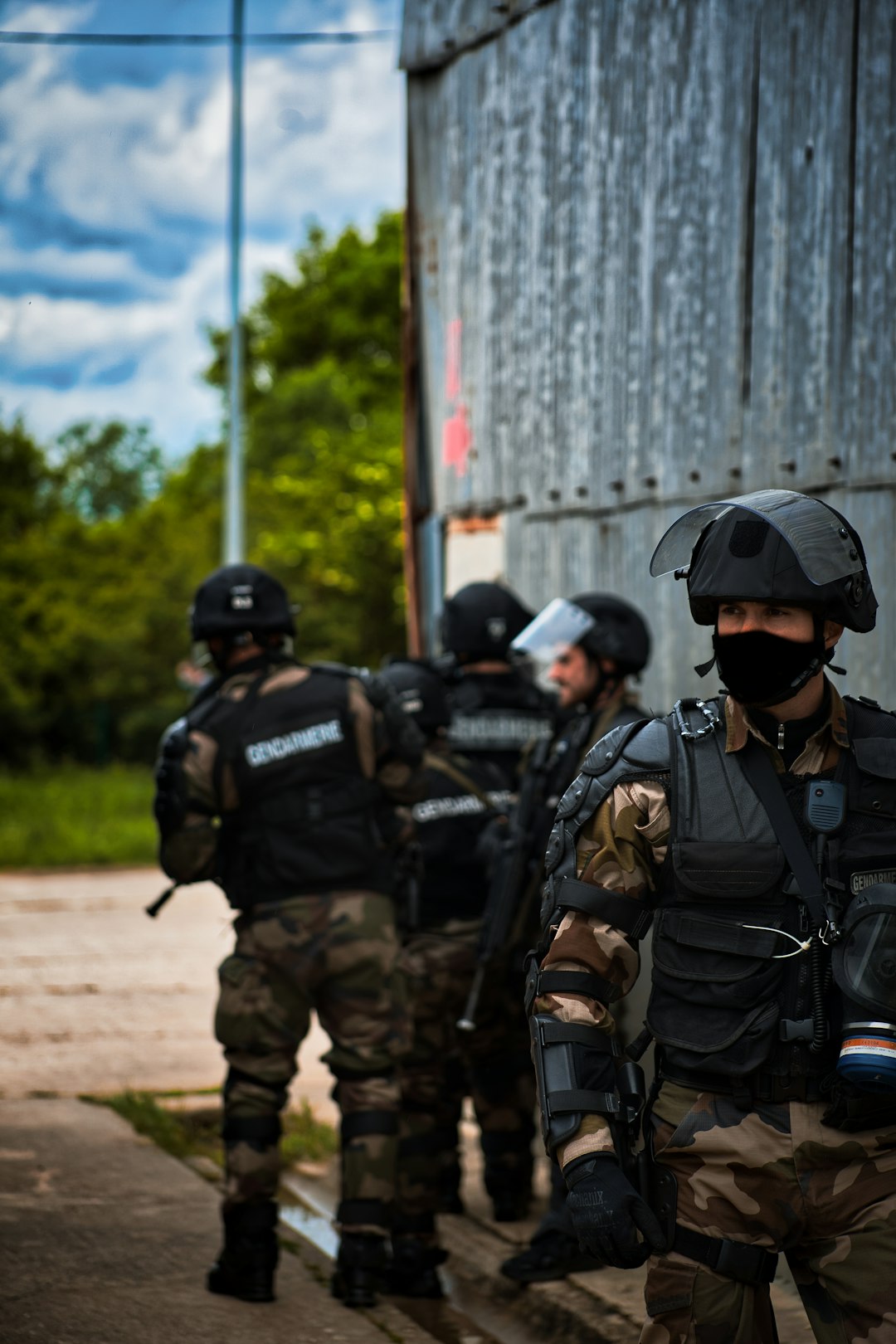 men in black and gray camouflage uniform standing on brown field during daytime