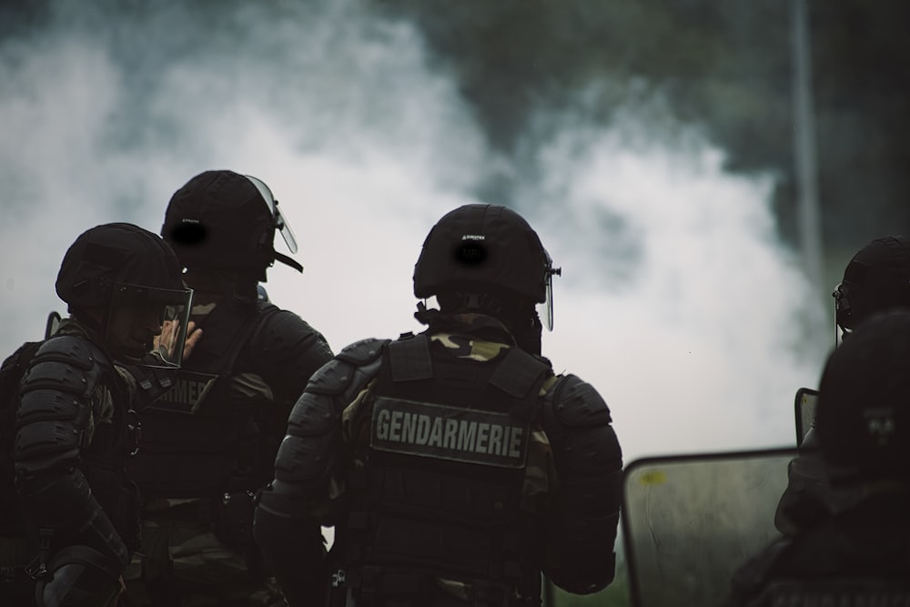 2 hommes en uniforme de police noir debout sur la route pendant la journée