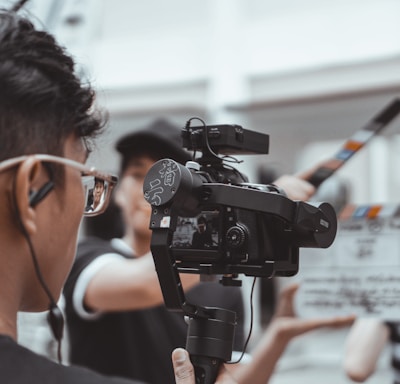 man in black framed eyeglasses holding black video camera