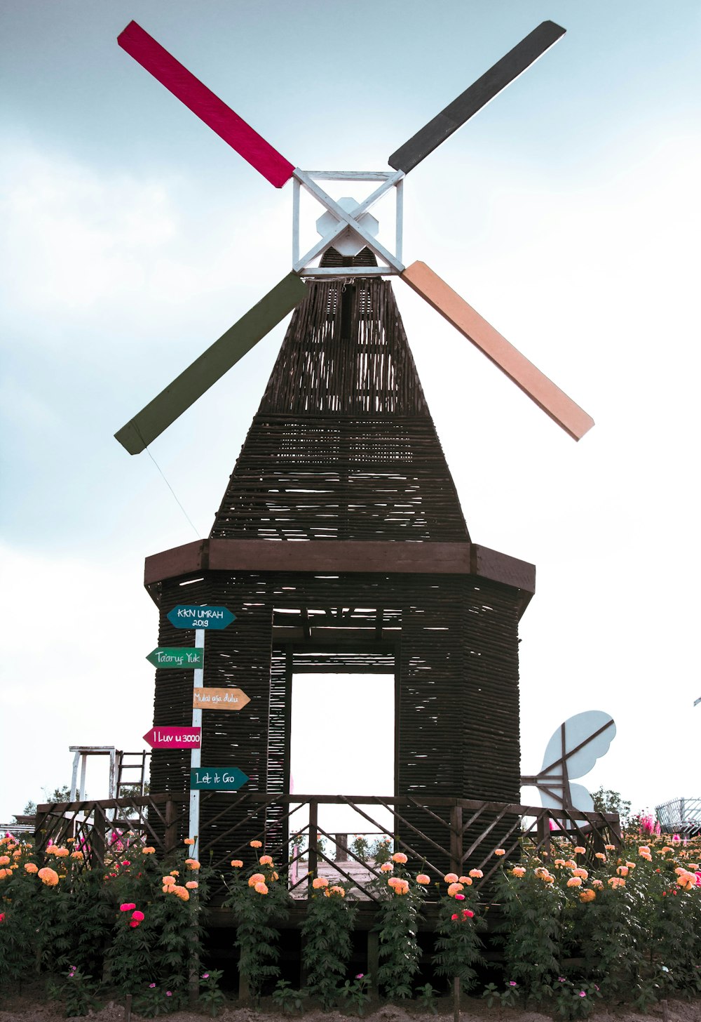 people walking on street near black and brown windmill during daytime