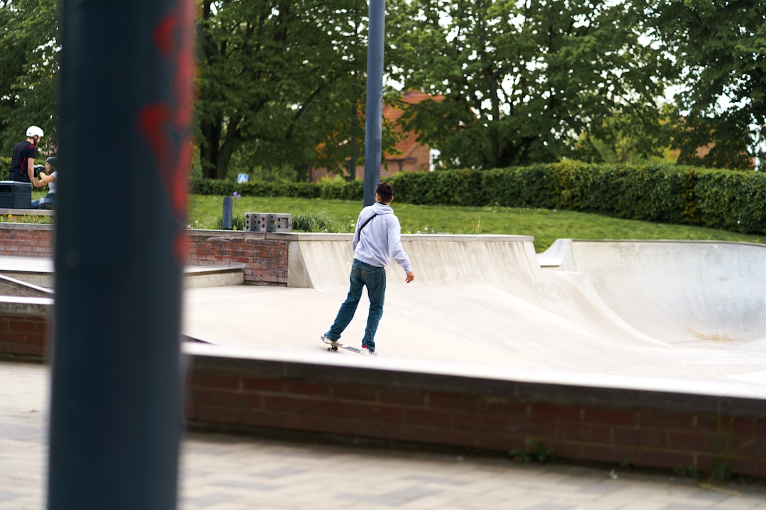 man in white long sleeve shirt and blue denim jeans walking on white concrete floor during