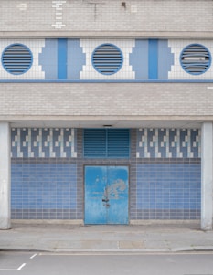 blue wooden door on white concrete building