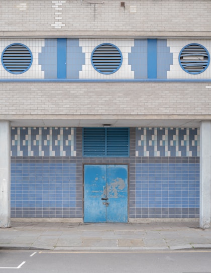 blue wooden door on white concrete building