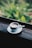 A steaming cup of coffee on a rustic wooden table surrounded by lush greenery.