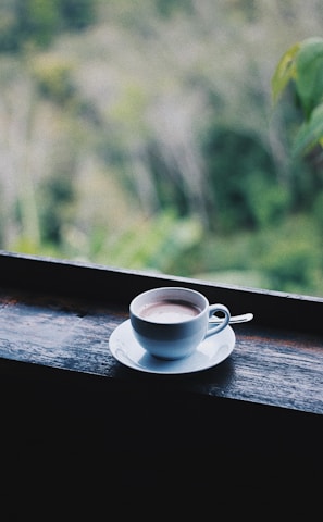 white ceramic cup on saucer on brown wooden table