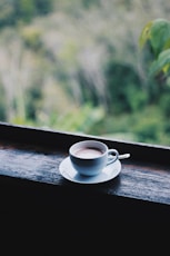 white ceramic cup on saucer on brown wooden table