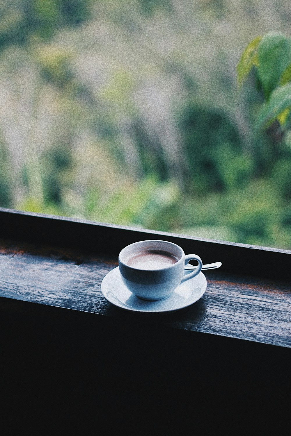 white ceramic cup on saucer on brown wooden table