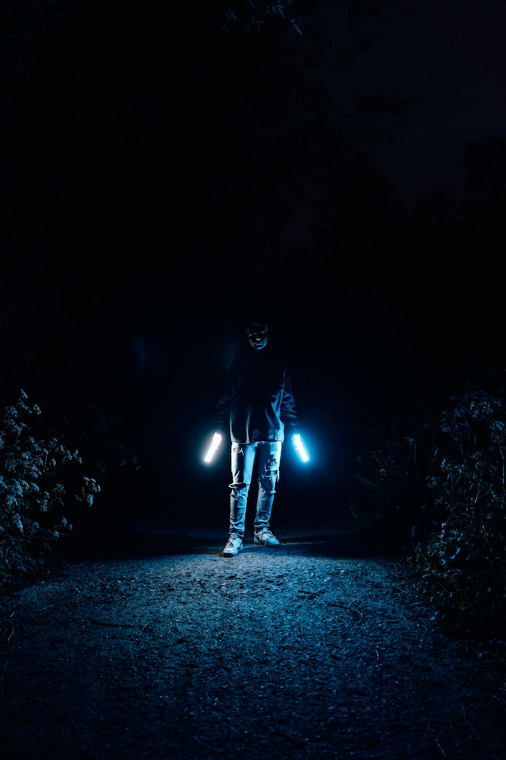 man in black jacket standing on the ground during night time