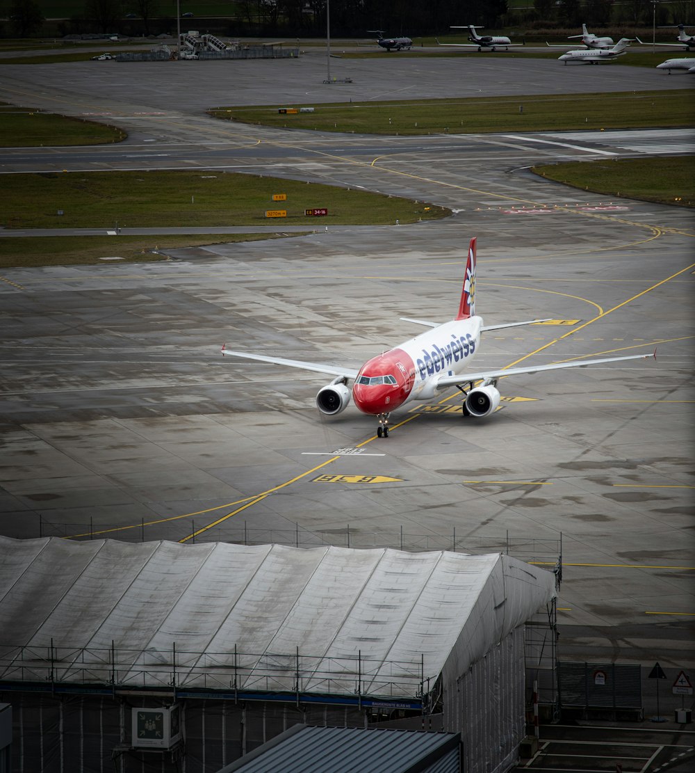 Avión blanco y rojo en el aeropuerto durante el día