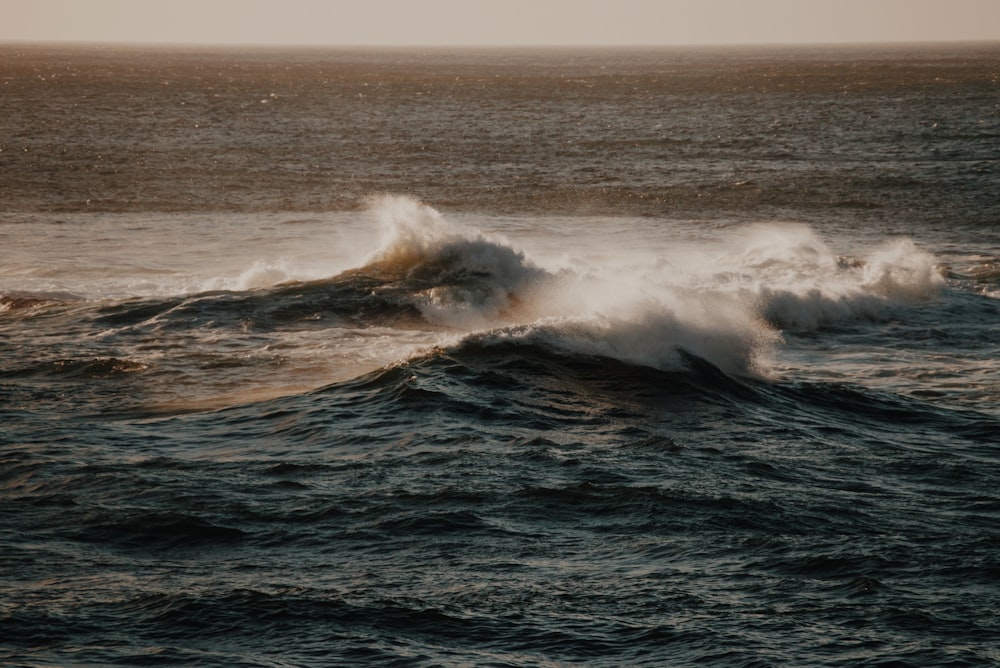 ocean waves crashing on shore during daytime