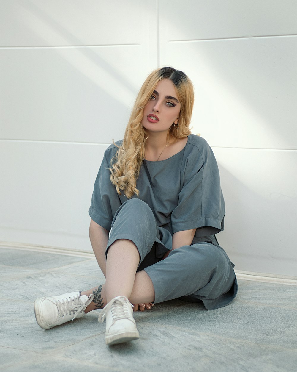 woman in gray shirt and gray pants sitting on floor