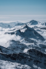 A panoramic view of snow-capped Himalayan peaks under a clear blue sky.