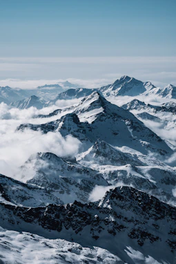 A panoramic view of snow-capped Himalayan peaks under a clear blue sky.