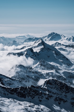 A panoramic shot of snow-capped Himalayan peaks under a clear blue sky.