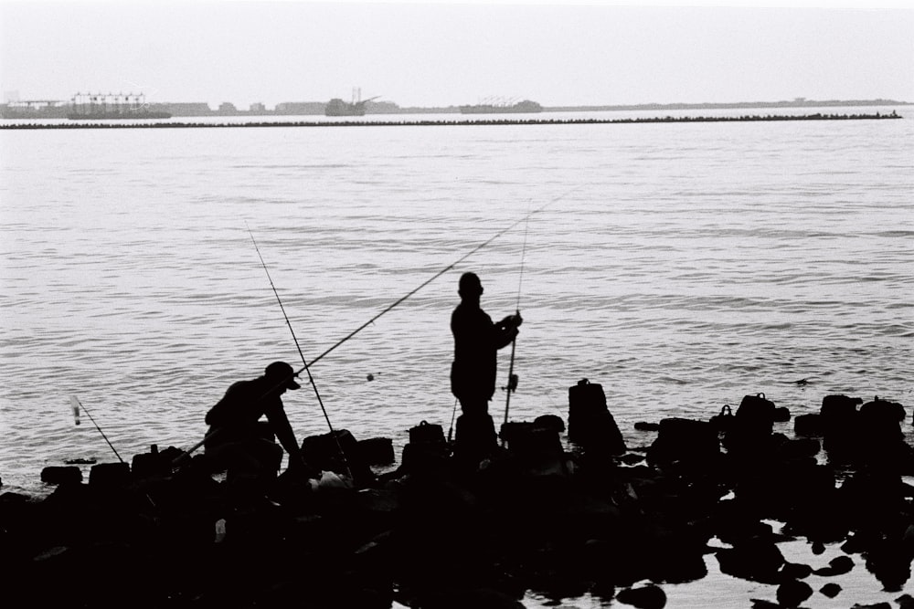 silhouette of people fishing on sea during daytime