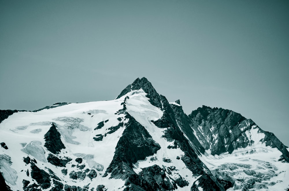 snow covered mountain under gray sky