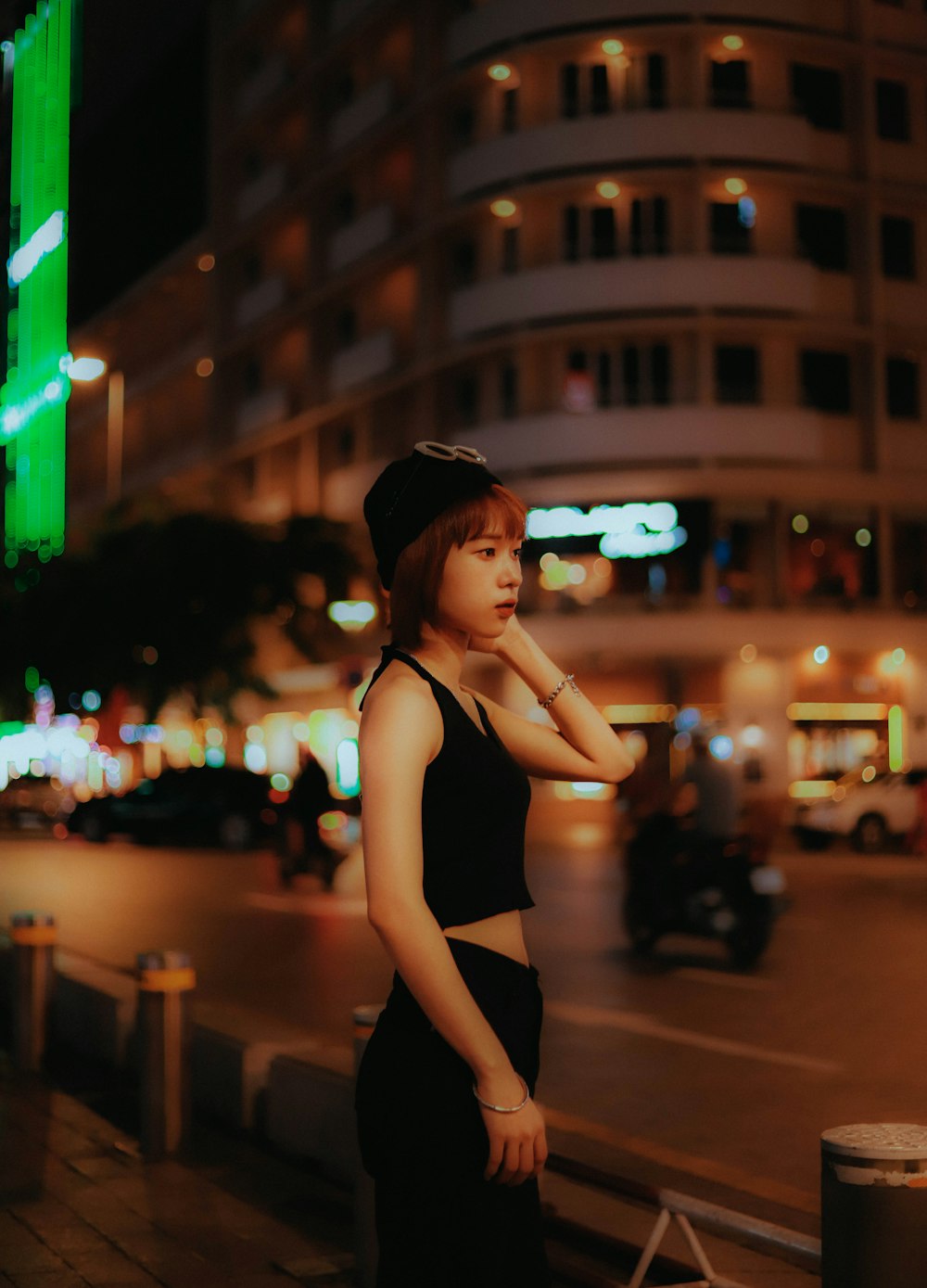 woman in black bikini top and black shorts standing on street during night time