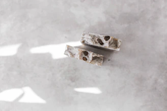 Rich Eternal Bloom soap bar surrounded by coffee beans and gentle steam rising, set against a sleek black background.