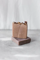 Artisan soap and liquid shampoo bars arranged on a rustic wooden surface.