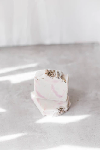 Artisan hand crafted soap bars stacked with fresh herbs and flowers nearby