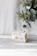 Close-up of a handmade natural soap bar with fresh plant extracts on a wooden surface.