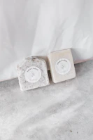 Artisan hands carefully crafting soap bars with natural ingredients in a minimalist lab setting.