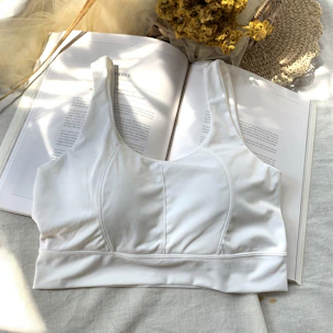 A neatly folded chest binder resting on a soft white surface, highlighting its breathable fabric.