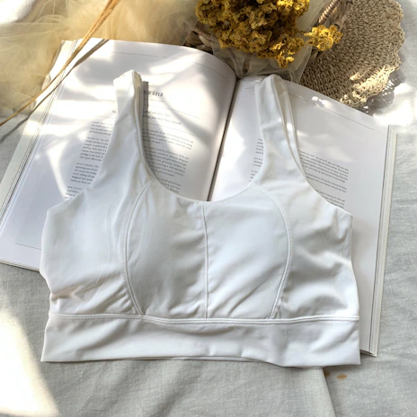 Comfortable white sports bra resting on a light gray textured surface