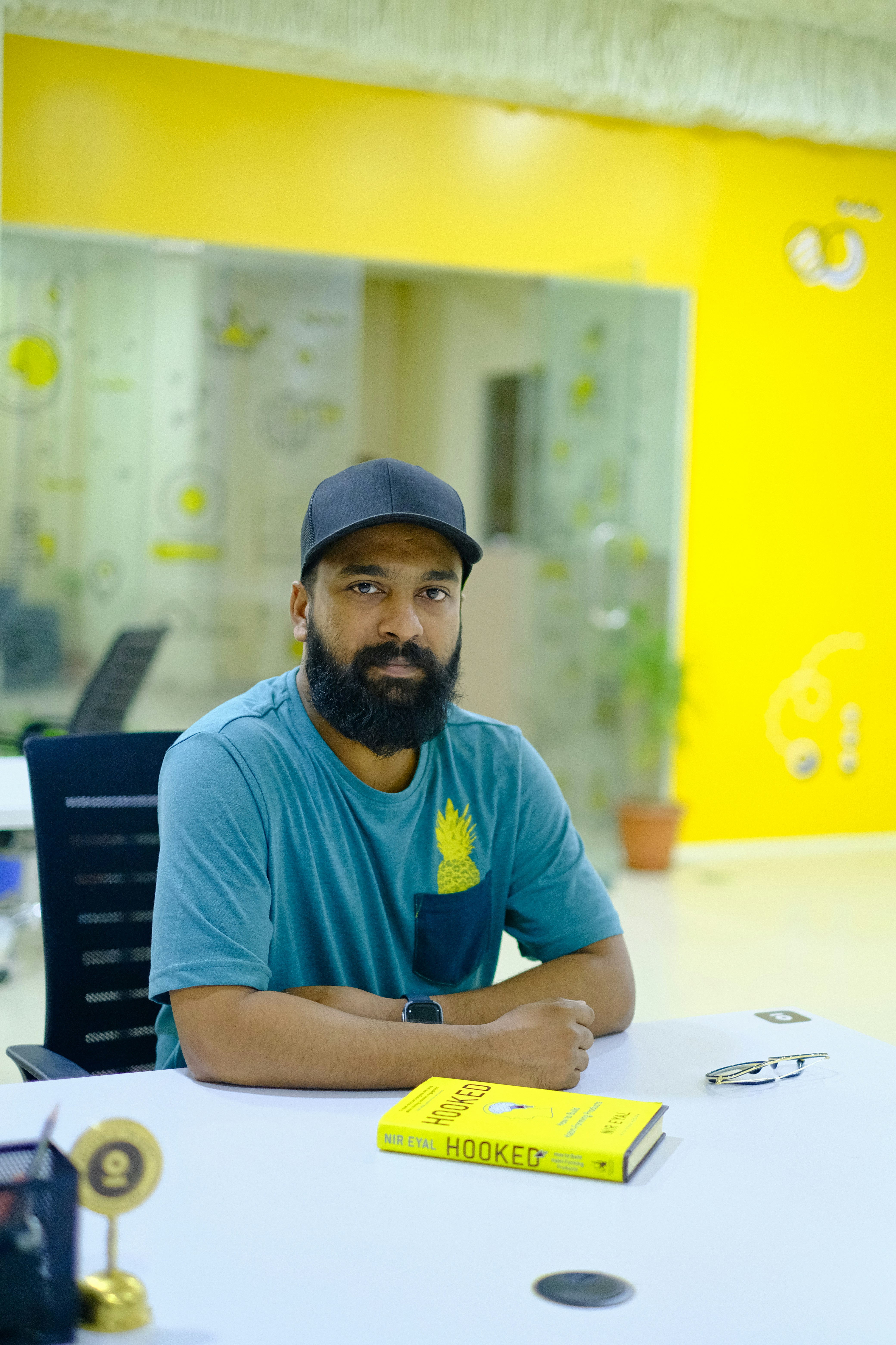 man in blue crew neck t-shirt wearing black cap sitting on chair