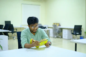 man in green long sleeve shirt holding yellow banana