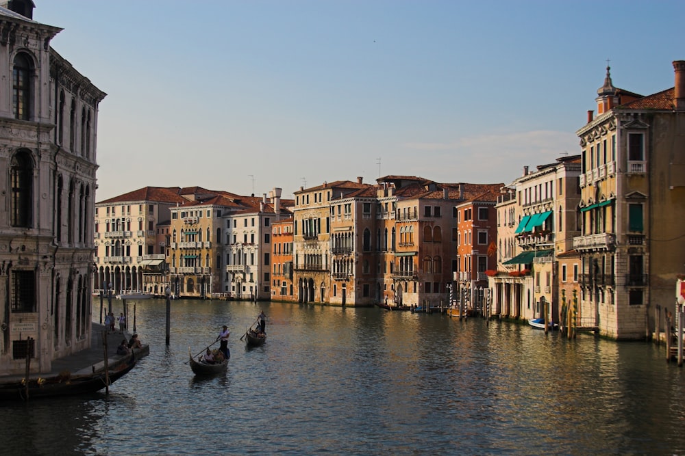 people riding on boat on river near buildings during daytime