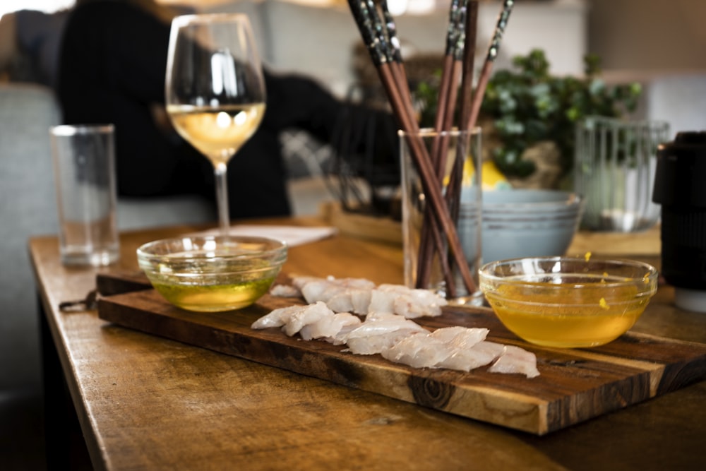 clear wine glass with yellow liquid on brown wooden table