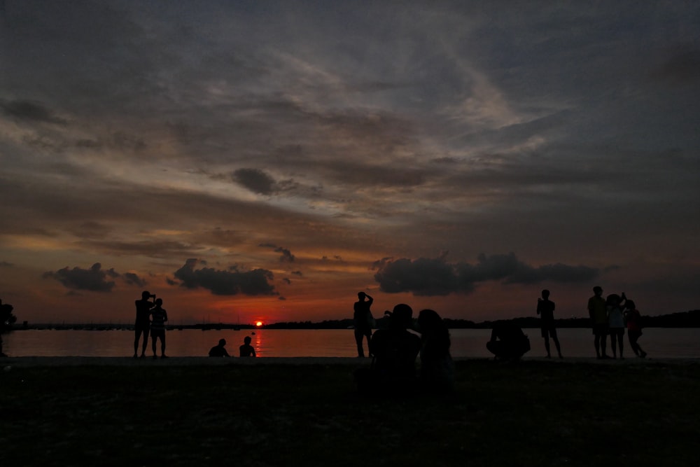 silhouette of people on beach during sunset