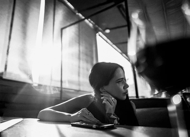 grayscale photo of woman sitting on chair
