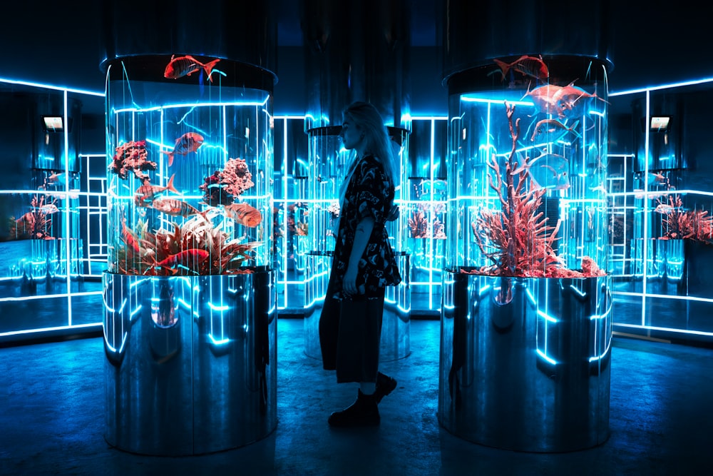 woman in black coat standing in front of lighted glass