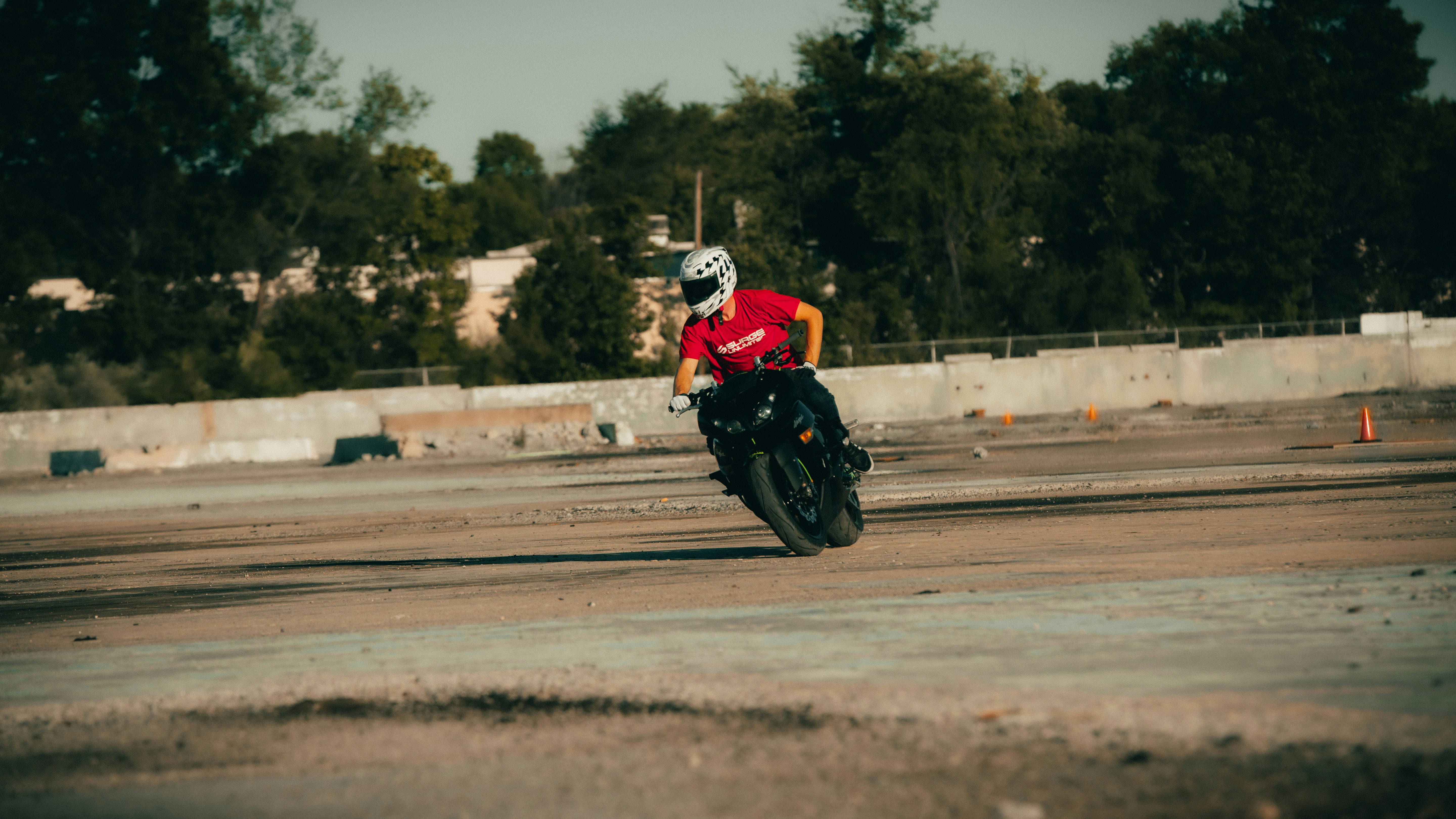 man in red and black motorcycle suit riding on red and white motorcycle during daytime