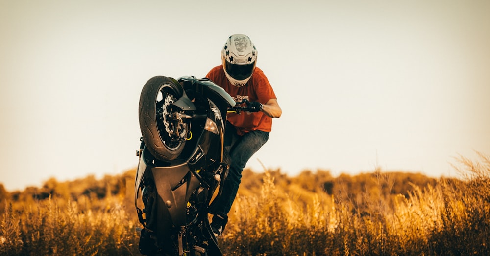 man in red jacket and helmet riding black motorcycle