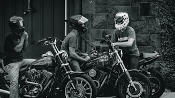 Sort-hvid billede- 3 motorcykler og 3 motorcyklister