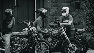 grayscale photo of man in helmet riding motorcycle