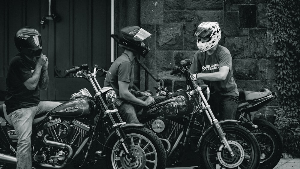 grayscale photo of man in helmet riding motorcycle