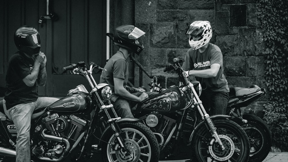 Foto in scala di grigi dell'uomo in sella al casco in moto