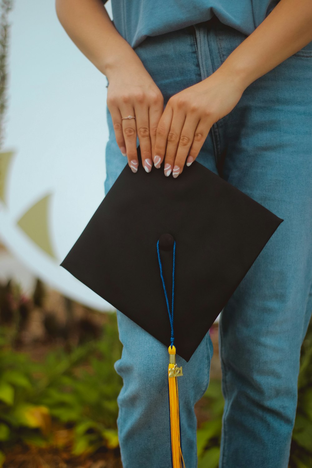 person in blue denim jeans holding black paper bag