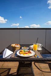 Guests enjoying a delicious breakfast on a sunny outdoor patio.