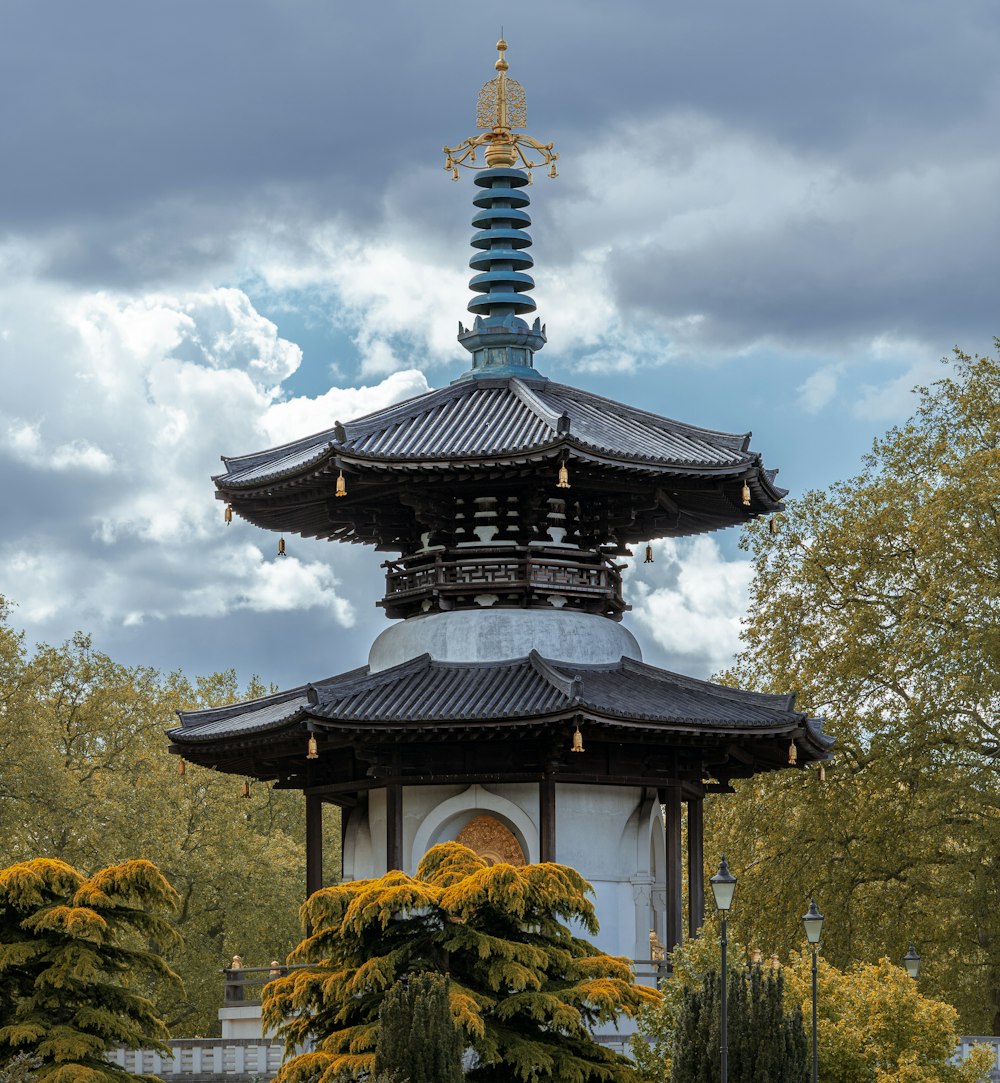 昼間の白い雲と青い空の下の黒と白の寺院