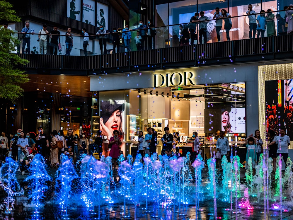 people in a city with blue lights during night time