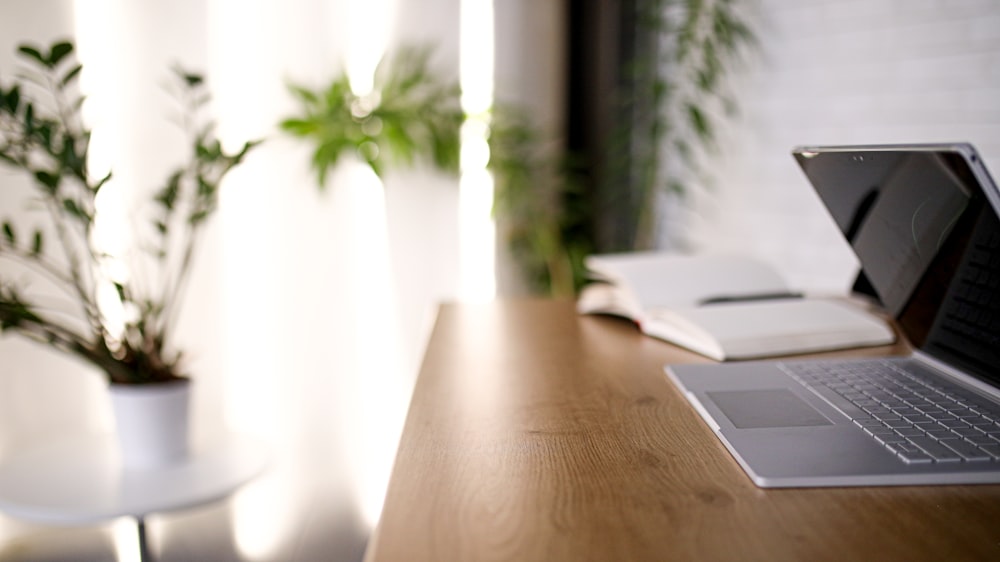 silver macbook on brown wooden table