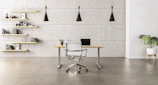 Wide shot of a minimalist office setup featuring custom shelving and a sleek desk.